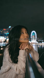 夜景摩天轮旁女子远眺