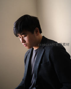 西装青年低头沉思神情专注