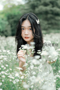 花丛中少女手捧雏菊