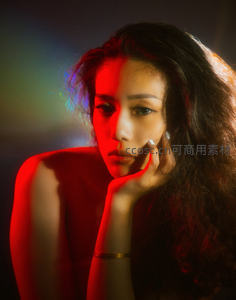 霓虹光影中的沉思女子，红蓝光晕渲染情绪