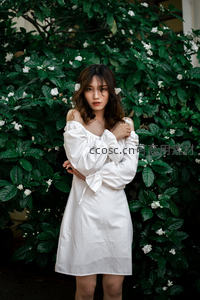 白裙佳人倚花丛，绿叶白花衬托纯净之美