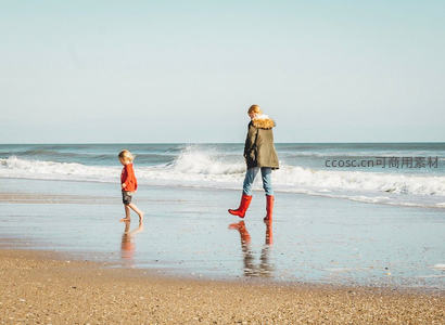 母子海边漫步，红靴踏浪逐沙
