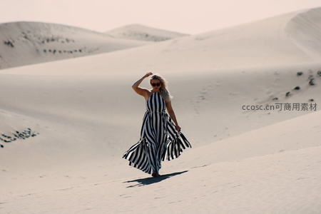 沙漠沙丘之上，条纹长裙飞扬