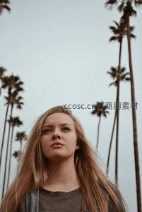 棕榈树下凝望天空的少女