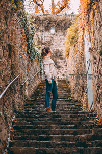 秋日石阶小巷中的沉思女子