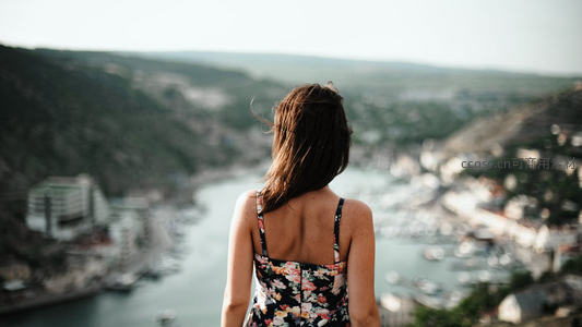 俯瞰港湾小镇的花裙女子背影