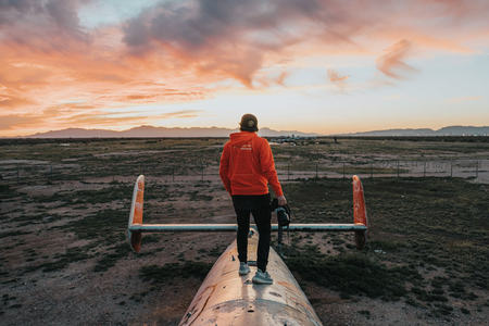 夕阳下站在废弃飞机上的旅人