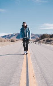 公路中央漫步的酷帅旅人