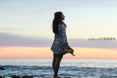 海边日落剪影，女子静立凝望远方