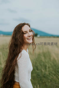 田野微笑，长发女子回眸绽放自然美