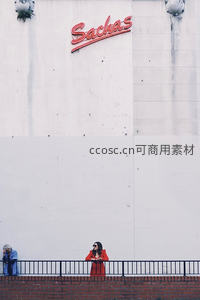红衣女子伫立 Sachas 霓虹招牌下