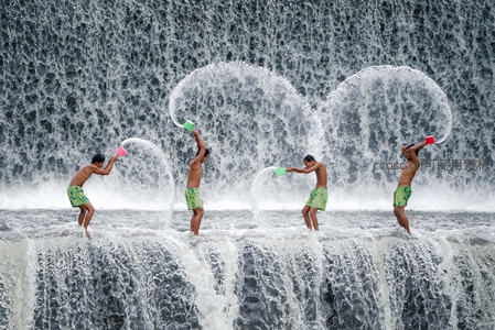 瀑布前四人泼水嬉戏，动感十足