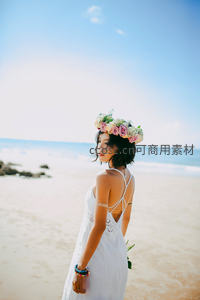 花环少女海边回眸，白裙飘逸蓝天作伴