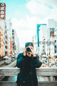 街头摄影师举相机抓拍，都市背景繁华