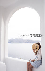 白色拱窗边凝望海景的女子