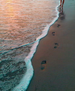 夕阳脚印，浪花轻吻金色沙滩