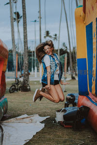 女孩在充气城堡旁开心跳跃