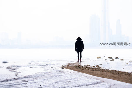 雪岸独行，身影走向雾中城市天际线