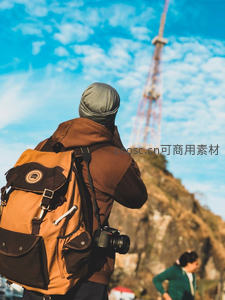 摄影师背影凝望铁塔，蓝天白云下的创作瞬间