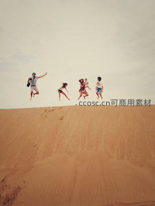 沙漠沙丘上欢乐跳跃瞬间