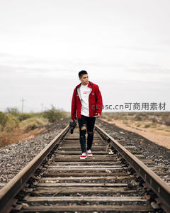 青年铁轨漫步，红衣相机记录荒野旅程