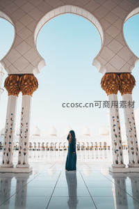 清真寺穹顶下，蓝袍女子静立如画