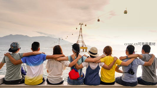 好友环抱看缆车，夕阳海景共享欢乐时刻
