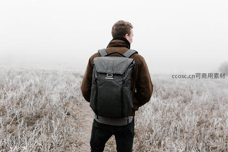 背包客独行于霜覆旷野凝望迷雾