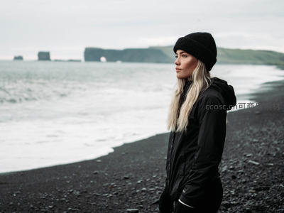 黑衣女子伫立冰岛黑沙滩凝望海景