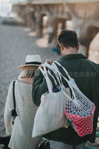 情侣携手漫步街头满载购物袋