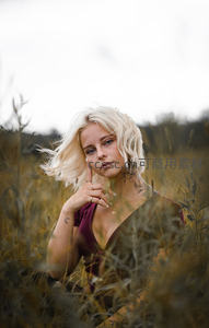 金发女子草丛中凝视镜头神秘