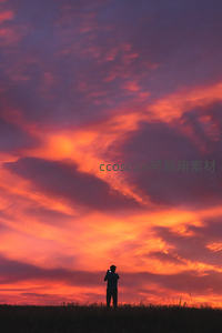 剪影人像仰拍绚烂晚霞，天空如火焰般燃烧