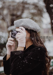 雪中少女持复古相机定格冬日瞬间
