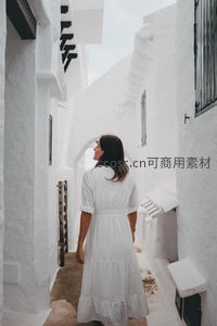 白衣女子漫步白色巷弄