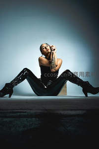 聚光灯下性感蜷坐的纹身女