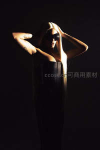 聚光灯下的神秘美人，双手抚发显优雅