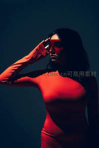 红色光影中的沉思女子