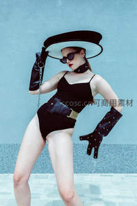 蓝墙前黑衣女郎戴帽造型