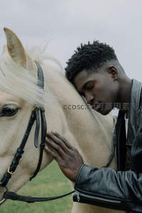 黑人青年温柔依偎白马的瞬间