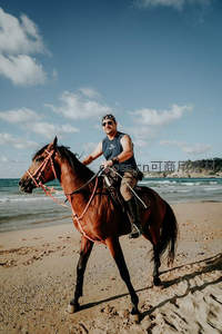 男子海边策马，享受自由驰骋时光