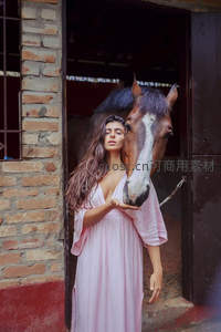 女子与马亲密依偎砖墙门廊温情