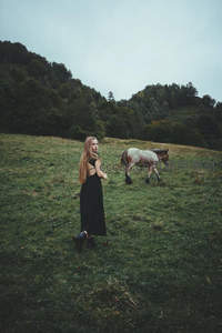 女子与马漫步山野草坡