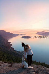 山顶日落时分，人与爱犬共赏美景