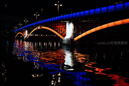 蓝橙光影下的拱桥倒影，如梦似幻