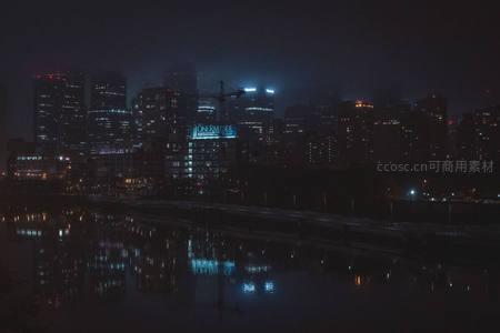 薄雾笼罩的城市夜景倒映在河面