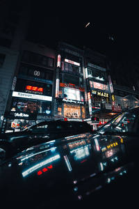 街头霓虹招牌映照车顶