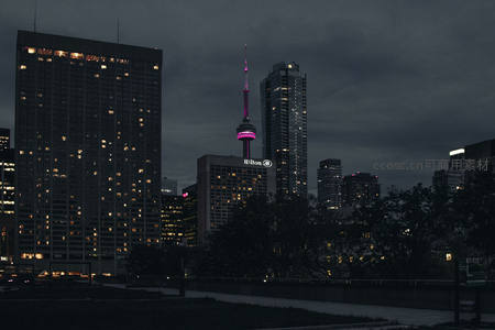 阴云笼罩下粉色塔尖点亮城市夜