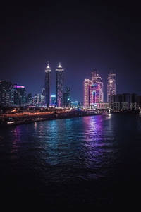 霓虹闪烁的都市夜景倒映在波光粼粼的水面上