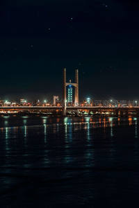 星空下斜拉桥与城市灯火的静谧倒影