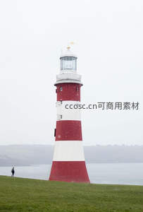 红白灯塔雪中矗立，孤影伴行人